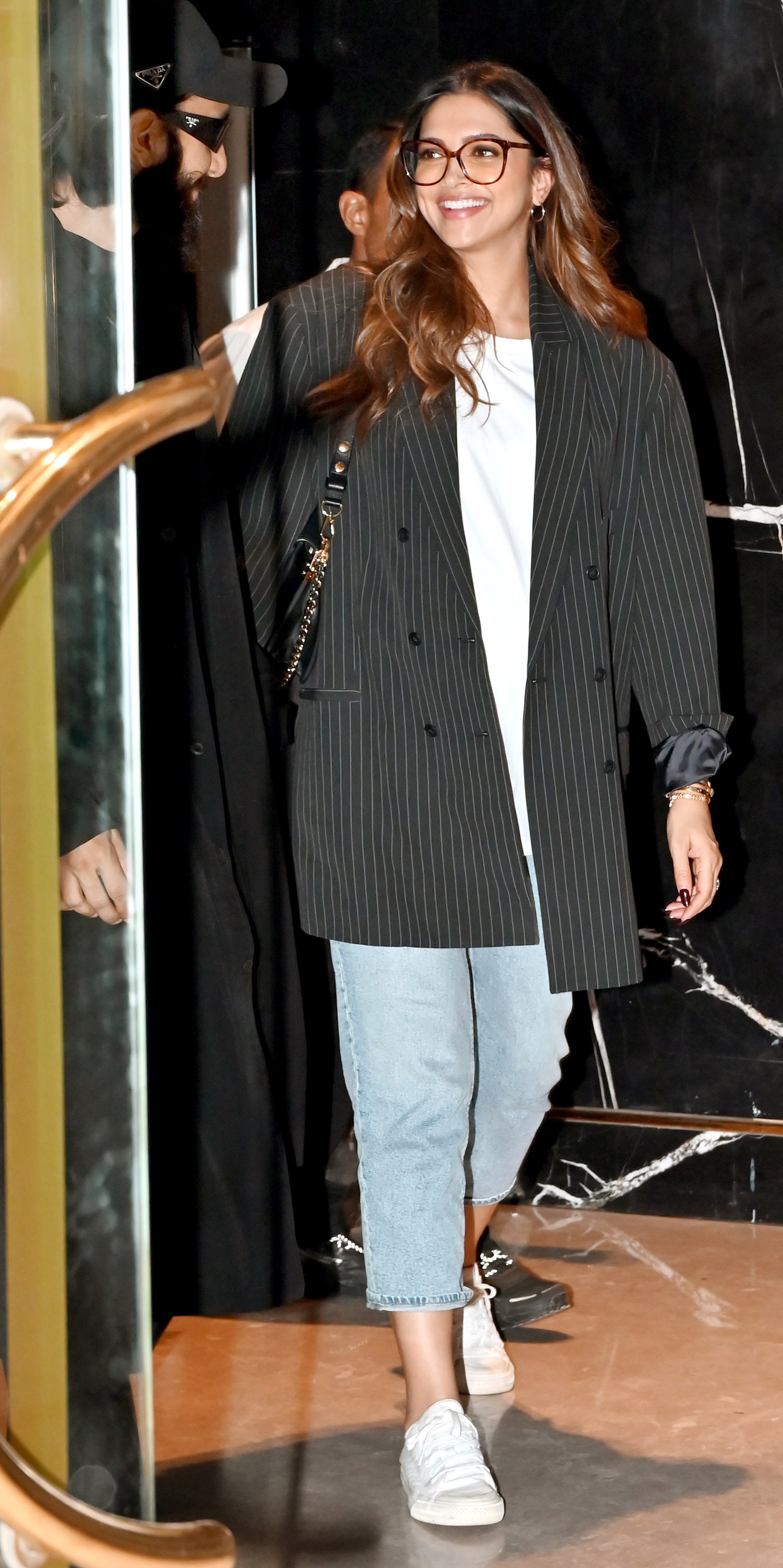 Deepika sports an oversized striped blazer with jeans.